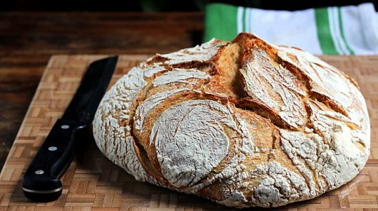 sourdough boule with kitchen towel and knife picassa