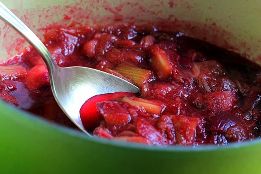 rhubarb sauce in green pot with spoon