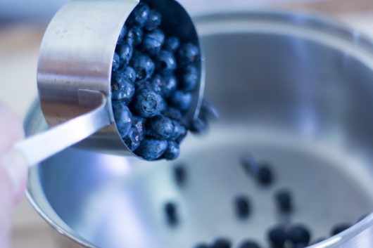 adding the blueberries to a saucepan