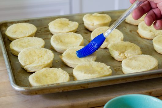 remove tops from biscuits and brush insides with melted butter