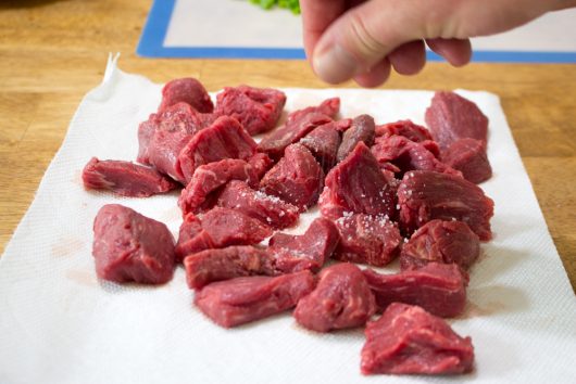 Seasoning the beef tips for Skillet Steak Dinner 