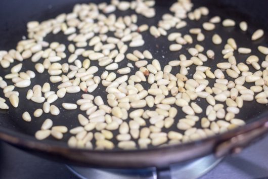 toasting the pine nuts for Green Beans Gremolata