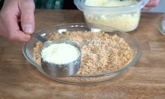 adding cheese to panko for Crispy Baked Chicken Parmesan