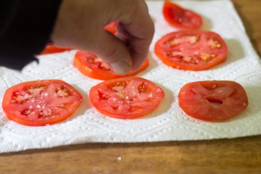 salting the tomato slices